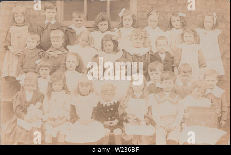 Vintage Edwardian photographische Postkarte zeigt eine Gruppe von britischen Schule Mädchen und Jungen aus dem Beverley Road Kinder Schule, Hull, Yorkshire im Jahre 1907. Stockfoto