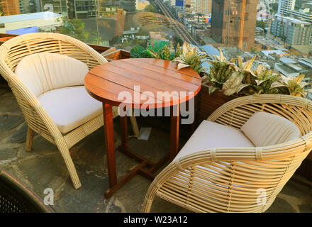 Leer Rattan Stühle mit runder Tisch auf der Dachterrasse Stockfoto