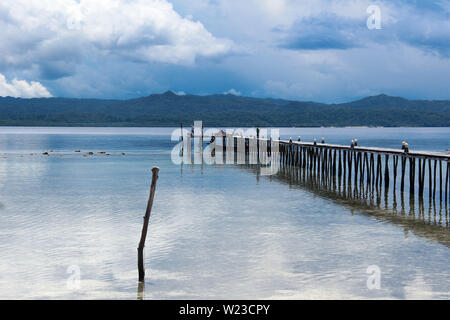 Traditionelle Holzsteg über ruhigen Wasser im Ozean in der Nähe der Insel Kri, Raja Ampat, Süd-Ost-Asien. Stockfoto