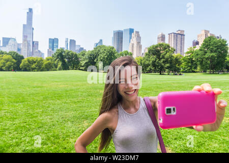 Gerne asiatische Frau, Smartphone selfie Foto mit Handy schafe wiese, Central Park. Mädchen touristische genießen Sie amerikanische Sommer Reisen Urlaub in New York City, Manhattan, USA. Stockfoto