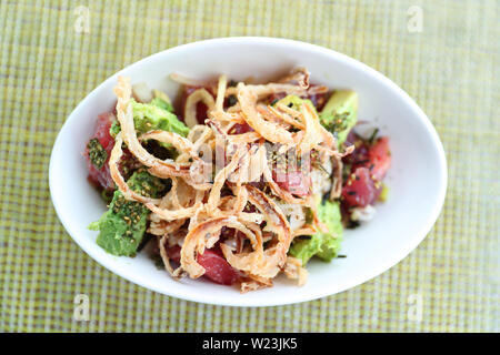 Hawaii poke Schüssel essen. Poke Schüssel Platte closeup auf Tisch im Restaurant. Frische rohe Ahi-Thunfisch mit gebratenen Zwiebeln, Reis und Avocado, bestreut mit Sesam. Hawaii japanese Fusion Food hawaiische Küche. Stockfoto