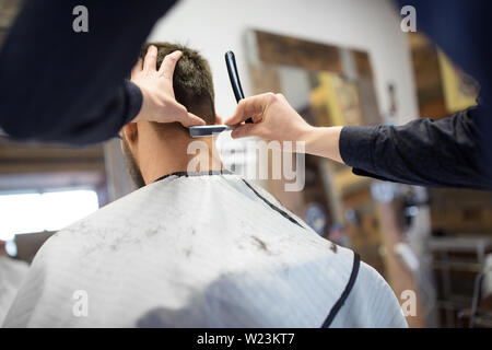 Mann und Barbier mit dem Rasiermesser rasieren Haar Stockfoto