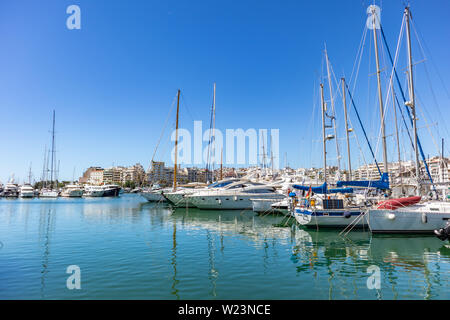 April 29, 2019. Marina Zeas in Piräus, Griechenland. Günstig Yachten sind bereit für die Kreuzfahrt. Reflexion der Boote, blaue Meer, die Stadt und die Himmel Hintergrund. Stockfoto