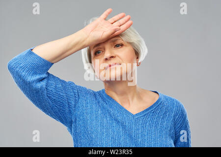 Müde senior Frau leidet unter Kopfschmerzen. Stockfoto