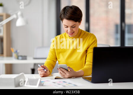 Lächelnd UI-Designer über Smartphone im Büro Stockfoto