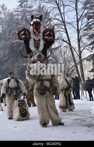 Razlog, Bulgarien - 12. Januar 2019: Volksfest in Starchevata und Maskerade. Die Leute kleideten sich als Kukeri auf der verschneiten Straße der Stadt Stockfoto