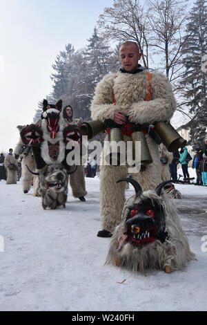 Razlog, Bulgarien - 12. Januar 2019: Volksfest in Starchevata und Maskerade. Die Leute kleideten sich als Kukeri auf der verschneiten Straße der Stadt Stockfoto