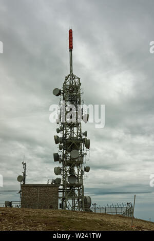 Industrielle high power Telecommunication Tower auf hohen Berg, düsteren bedeckt Stockfoto