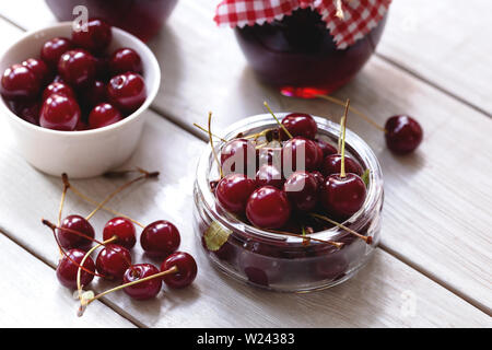 Schale mit Kirschen und hausgemachter Marmelade im Glas Stockfoto