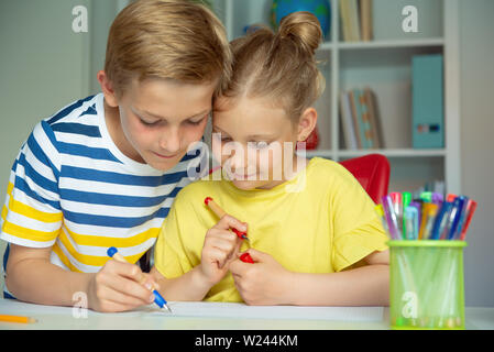 Cute Schulkinder sind kam zurück in die Schule und Lernen in der Tabelle im Klassenzimmer Stockfoto