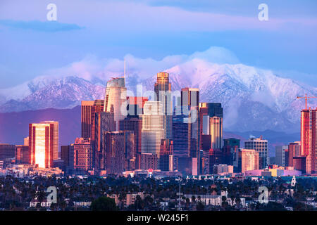 Downtown Los Angeles Skyline mit schneebedeckten Bergen hinter bei Sonnenuntergang Stockfoto