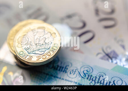 Makro Foto von einem Pfund, die Münzen und das Britische Pfund Banknoten unterschiedlicher Stückelung. Stockfoto