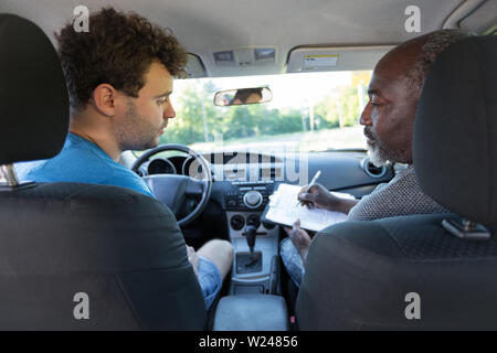 Fahrlehrer und Student an der Vorderseite des Fahrzeugs Stockfoto