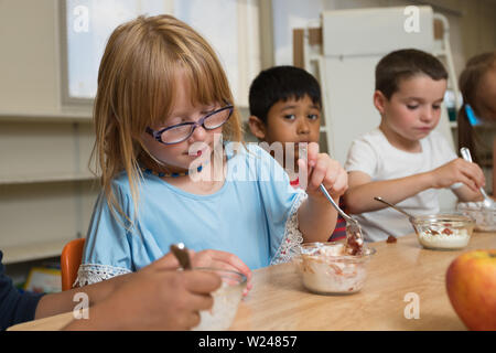 Grundschulkinder Mit Gesunden Snack Im Klassenzimmer In Der Schule Während Der Mittagspause, Multirassische Kinder Stockfoto