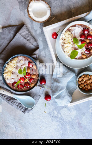 Gesunde cherry Coconut smoothie Schüssel mit Banane und Mandeln Stockfoto