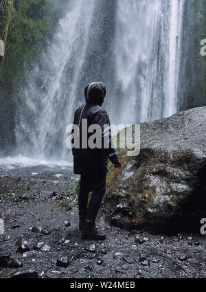 Eine Person admirnig die Schönheit der Skogafoss Wasserfall in Island entfernt) Stockfoto