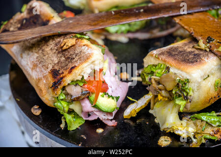 Kalorie köstliche Sandwiches aus organischen französische Baguettes, die mit Schinken, Tomaten, Käse, Salate und Gewürzen gebacken auf einem Teller gefüllt sind, so dass Fa Stockfoto