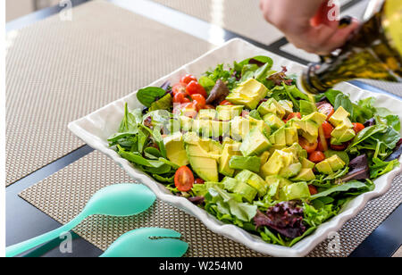 Für Liebhaber von einem gesunden Lebensstil und für diejenigen, die Gewicht verlieren und sich fit halten, eine organische, Salat, Tomaten und Avocado, gewürzt mit Olivenöl Stockfoto