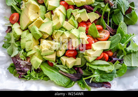 Für Liebhaber von einem gesunden Lebensstil und für diejenigen, die Gewicht verlieren und sich fit halten, eine organische, Salat, Tomaten und Avocado, gewürzt mit Olivenöl Stockfoto