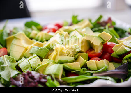 Für Liebhaber von einem gesunden Lebensstil und für diejenigen, die Gewicht verlieren und sich fit halten, eine organische, Salat, Tomaten und Avocado, gewürzt mit Olivenöl Stockfoto