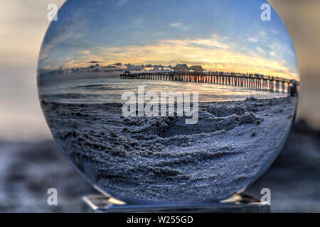 Crystal Ball Sonnenuntergang am Naples Pier am Strand von Naples in Naples, Florida. Stockfoto