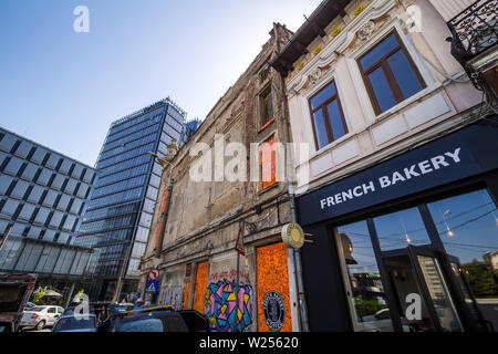 Bukarest, Rumänien - Juli 07, 2019: Ein modernes Hochhausgebäude, genannt die Markierung Turm, im Gegensatz zu einigen alten Gebäuden auf einer Straße in Bucha Stockfoto