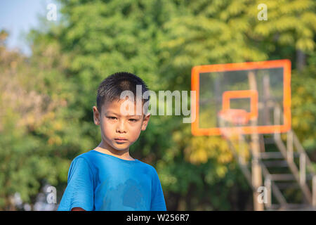 Portrait von asiatischen Jungen Schwitzen Gesicht Hintergrund am Basketballplatz. Stockfoto