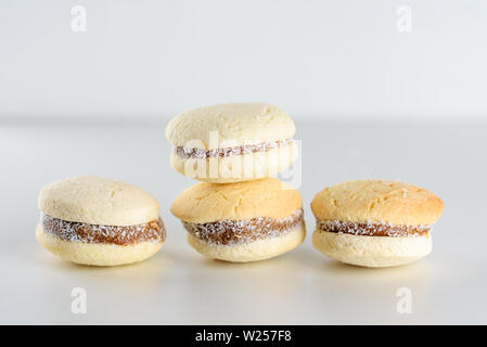 Alfajores mit köstlichen argentinischen Cookies Cream dulce de leche Close-up auf den Tisch. Weiße Vanille Makronen auf weißem Hintergrund. Französische zarte Dessert für Frühstück im Morgenlicht. Stockfoto