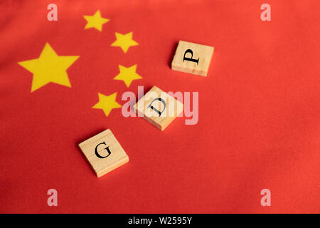 Bruttoinlandsprodukt oder BIP von China auf den Holzblock Buchstaben auf der Chinesischen Flagge Stockfoto