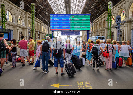 Leute, die am Abfahrtstafel am Bahnhof Keleti in Budapest schauen Stockfoto