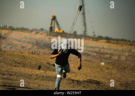 Gaza, Palästina. 05. Juli, 2019. Eine palästinensische Demonstrator verwendet eine Schleuder Steine auf israelische Streitkräfte während einer Demonstration für ein Ende der Belagerung des Gazastreifens im südlichen Gazastreifen zu werfen. Credit: SOPA Images Limited/Alamy leben Nachrichten Stockfoto