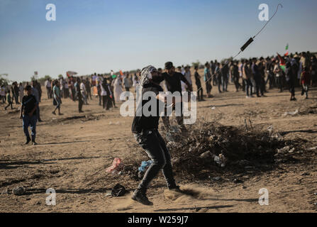 Gaza, Palästina. 05. Juli, 2019. Eine palästinensische Demonstrator verwendet eine Schleuder Steine auf israelische Streitkräfte während einer Demonstration für ein Ende der Belagerung des Gazastreifens im südlichen Gazastreifen zu werfen. Credit: SOPA Images Limited/Alamy leben Nachrichten Stockfoto