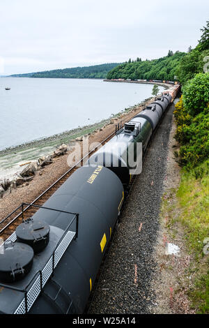 Lange nördliche Burlington Güterzug bewegen sich entlang der Küste von Puget Sound. Stockfoto