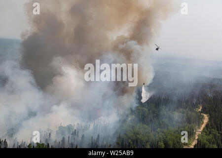 Alaska Army National Guard UH-60 Blackhawk Mannschaften von 1-207 th Aviation Arbeiten zur Unterstützung der Abteilung der Forstwirtschaft Besatzungen ein wildfire bei Montana Creek in der Nähe von Talkeetna, Alaska Juli 4, 2019 zu kämpfen. (U.S. Army National Guard Foto von SPC. Michael Risinger/Freigegeben) Stockfoto