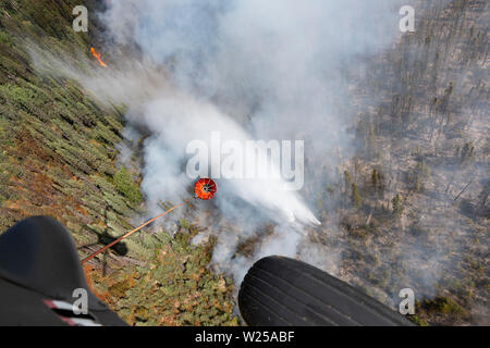 Alaska Army National Guard UH-60 Blackhawk Mannschaften von 1-207 th Aviation Arbeiten zur Unterstützung der Abteilung der Forstwirtschaft Besatzungen ein wildfire bei Montana Creek in der Nähe von Talkeetna, Alaska Juli 4, 2019 zu kämpfen. (U.S. Army National Guard Foto von SPC. Michael Risinger/Freigegeben) Stockfoto