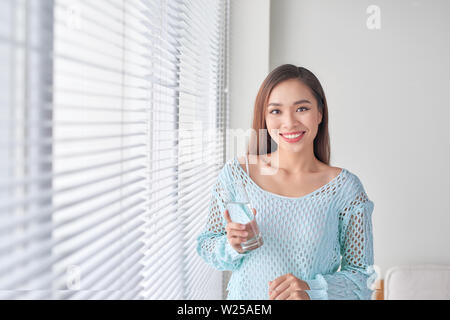 Schöne junge Frau Trinkwasser zu Hause Stockfoto