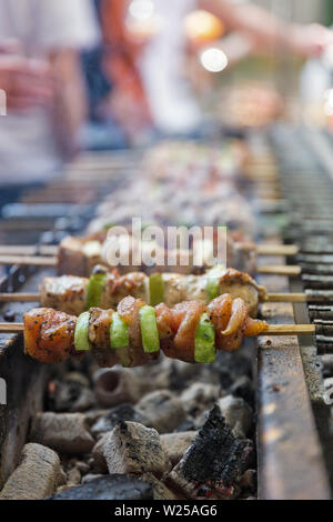 Appetitlich Schaschlik mit Putenfleisch und Zucchini gebraten am Spieß, closeup draußen. Street Food. Stockfoto