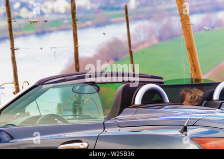 Cabrio Fahrt entlang der malerischen Küstenstraße auf den beeindruckenden felsigen Ufer in Richtung der schönen Weinberge. Glückliche Frau im Sommer vacati Stockfoto