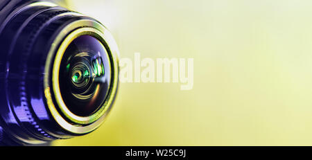 Seitenansicht der Kamera mit gelber Hintergrundbeleuchtung. Horizontale Fotografie. Banner Stockfoto