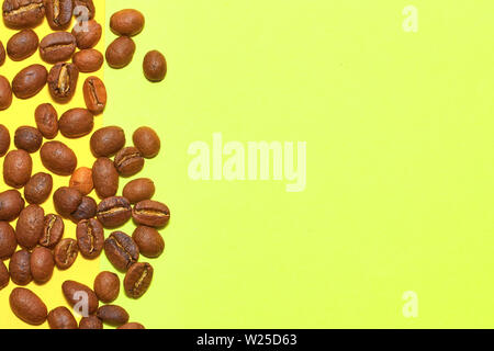 Kaffeebohnen isoliert auf den gelben Hintergrund. Freudige minimal Kaffee - Thema mit Kopie Raum Stockfoto