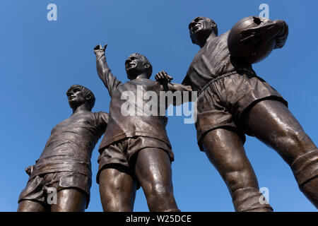 "Die Vereinigten Trinity" - eine Skulptur außerhalb von Old Trafford von Manchester United Football Stadium, mit George Best und Denis Law und Sir Bobby Charlton Stockfoto