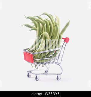 Mini Warenkorb voll mit grünen Bohnen über grauer Hintergrund Stockfoto