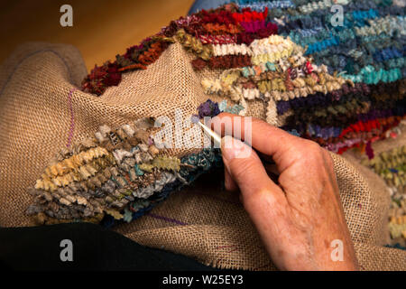 UK, Cumbria, Sedbergh, Fernfeld Mühle, Hände der Textilkünstlerin, rag Rug von Harris Tweed Reste Stockfoto