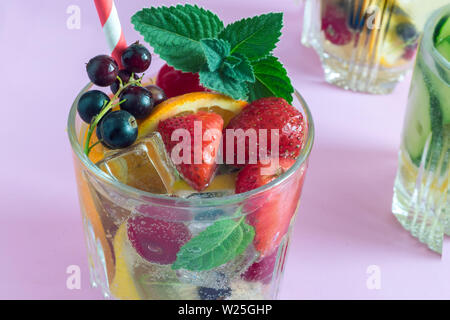 Sommer erfrischende Cocktail aus natürlichen Früchten und verschiedenen Beeren mit Eis und Minze mit Wasser aufgegossen. Enthält Zitrone, Orange, Erdbeere, Cher Stockfoto