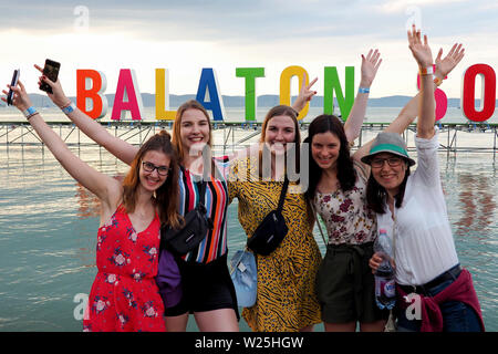 (190706) - ZAMARDI, Juli 6, 2019 (Xinhua) - Leute nehmen Fotos vor dem Logo der Balaton Sound Music Festival am Ufer des Balaton in Zamárdi, Ungarn, am 5. Juli 2019. (Xinhua / Attila Volgyi) Stockfoto