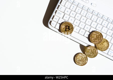 Blick von oben auf die Goldmünzen mit bitcoin liegen auf weißen Computer Tastatur und weißer Tisch. Konzept der Finanzen und Business im Internet. Handel virtuelle Cryp Stockfoto