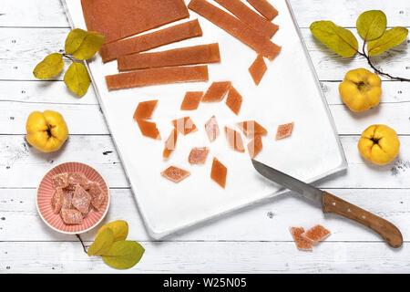 Schneiden Sie Stücke von hausgemachten Quitten Marmelade mit Zucker auf backblech. Ansicht von Oben. Stockfoto