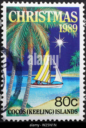 Kleines Segelboot in der Nacht auf Briefmarke von Cocos Inseln Stockfoto