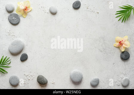 Spa-Konzept auf weißem Stein, Palm Blätter, Blumen, Kerzen und zen wie Graue Steine, Ansicht von oben, kopieren. Stockfoto
