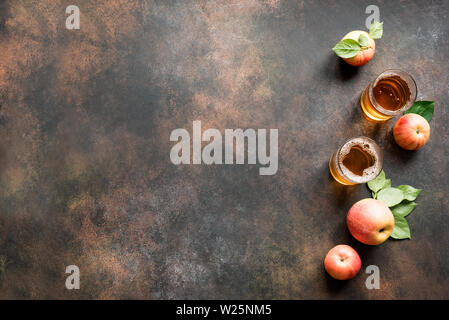 Apple Cider trinken oder vergorenen Obst trinken und organische Äpfel auf dunklen, Ansicht von oben, kopieren. Gesundes Essen und Lifestyle Konzept. Stockfoto